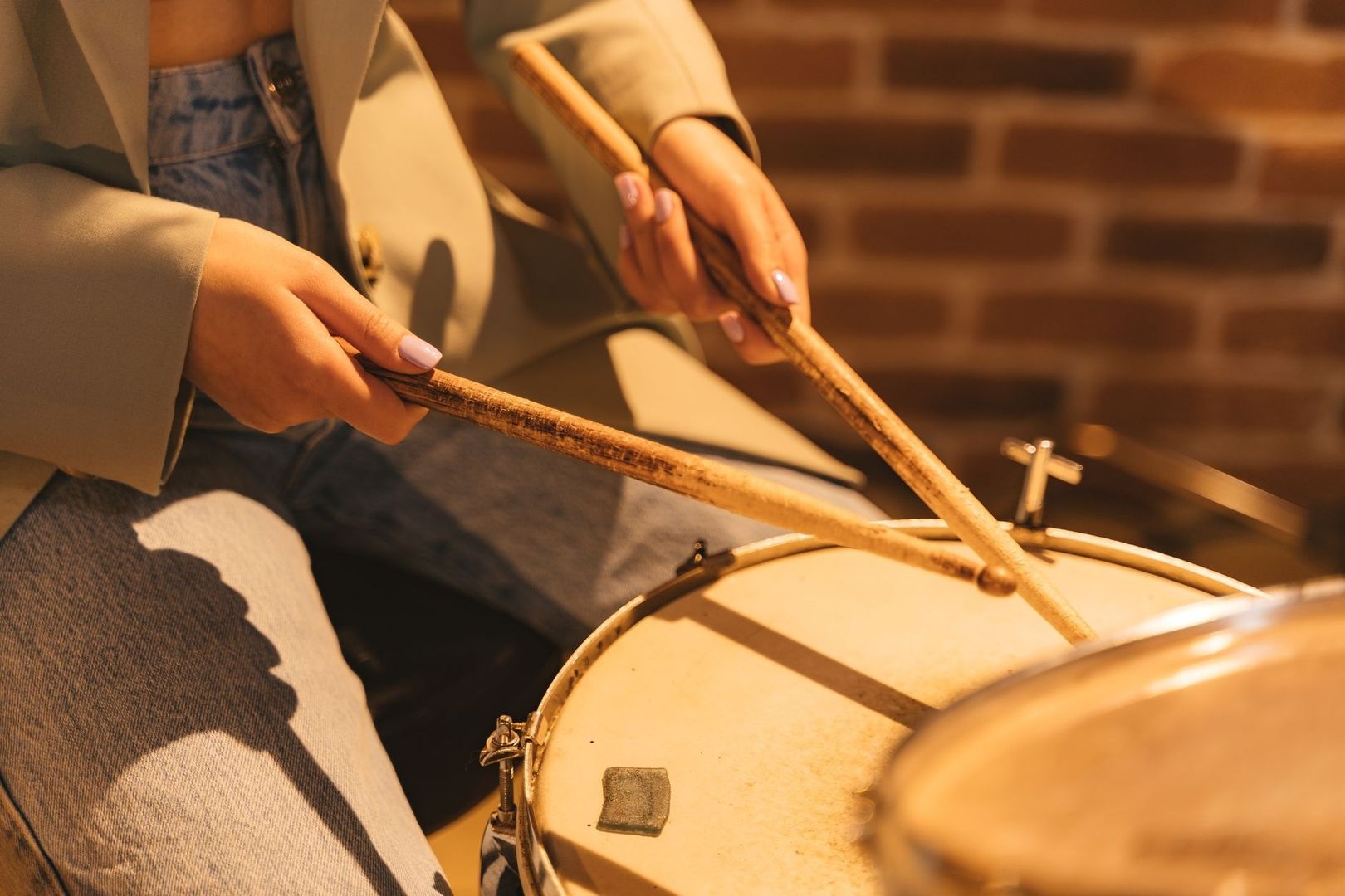 Nahaufnahme einer Hand mit Trommelstöcken über einer Snare-Drum