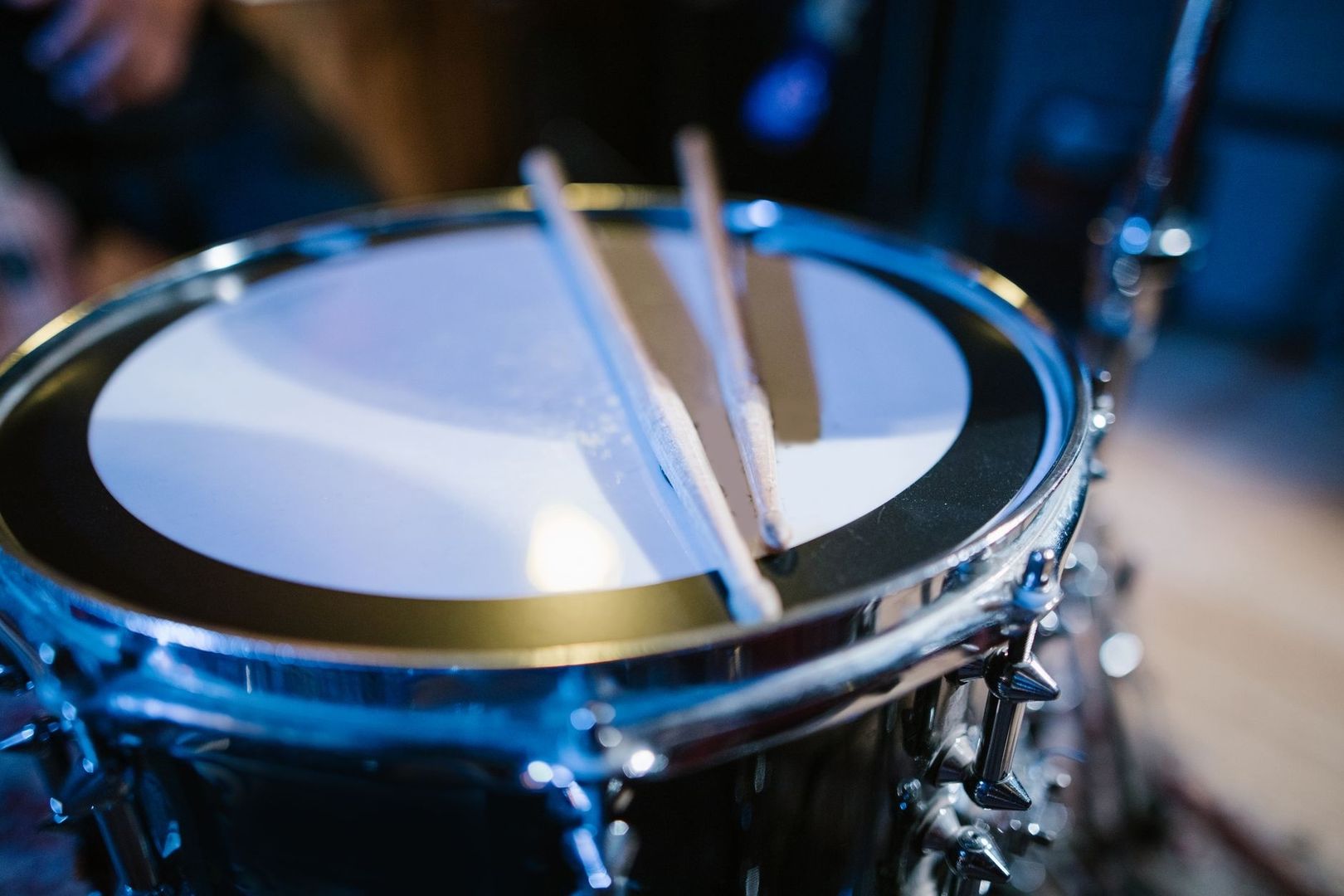 Nahaufnahme einer Snare-Drum mit zwei aufgelegten Trommelstöcken